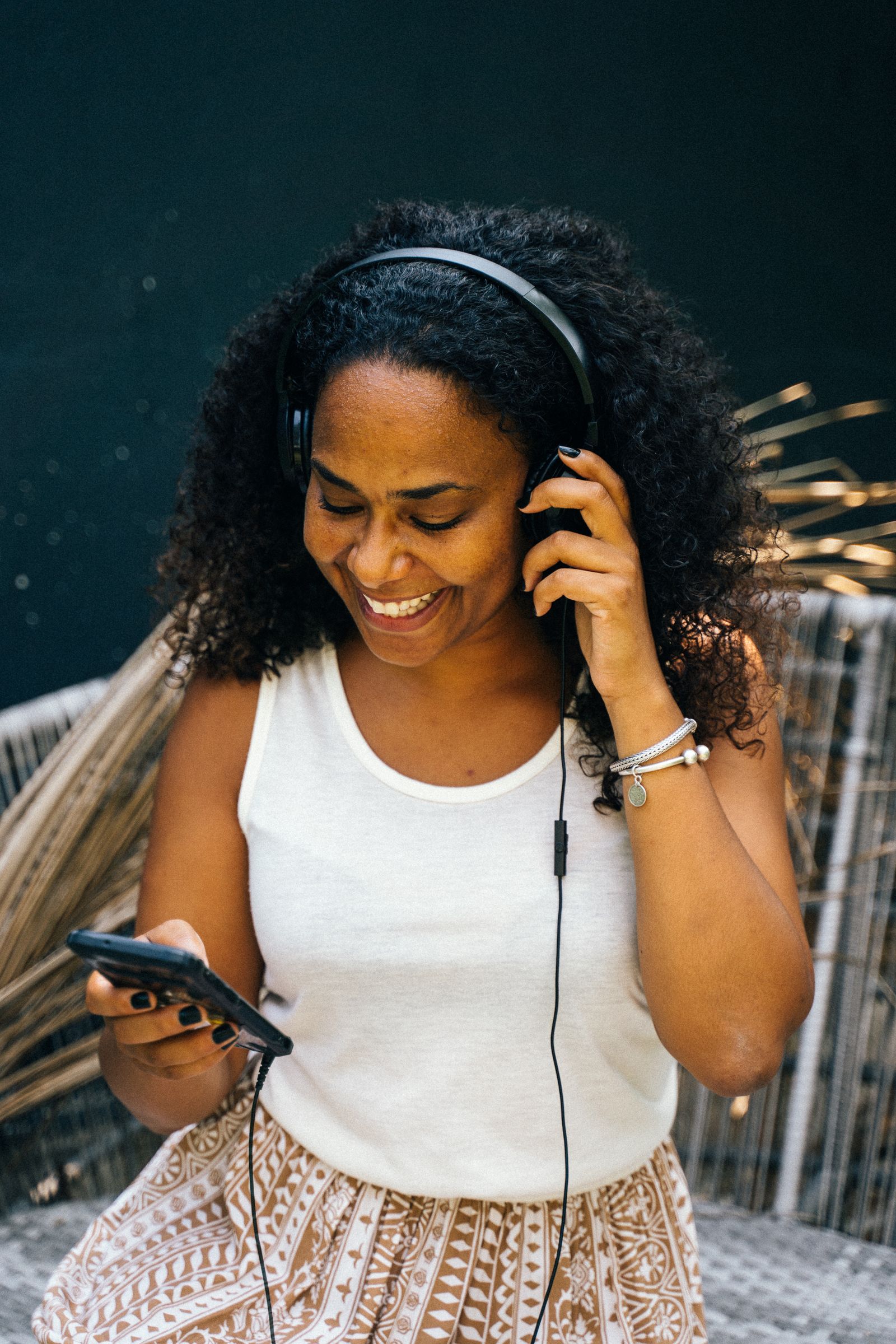A person relaxing at home and listening to a podcast episode through headphones